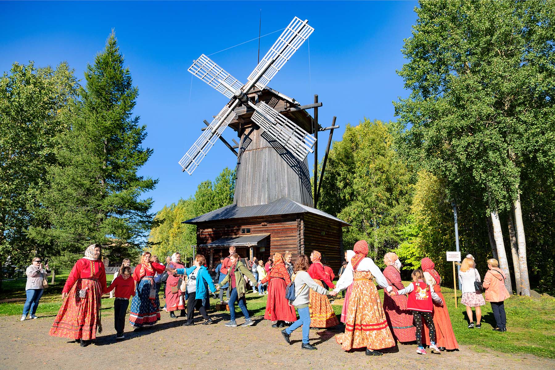 Хоровод возле деревянной мельницы в Музее деревянного зодчества в Малых Корелах, Архангельская область