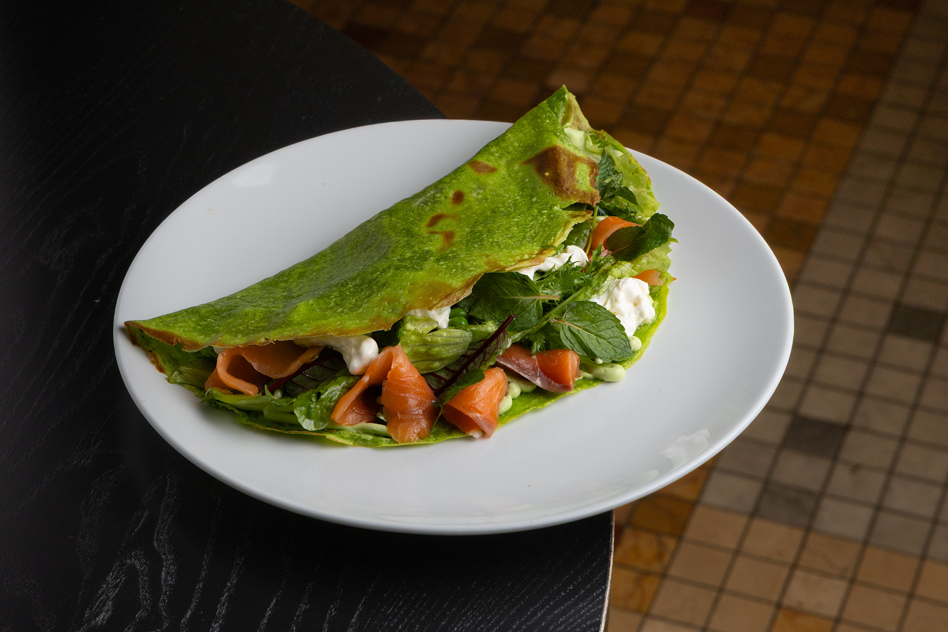 Большой зелёный блин с салатом, страчателлой и слабосолёным лососем