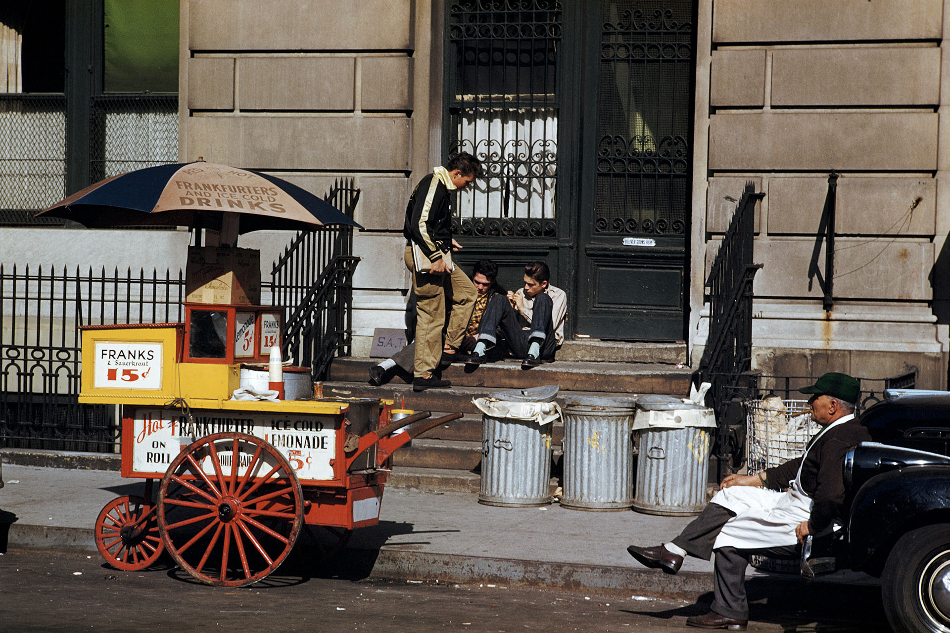 Продавец хот-догов (справа) делает перерыв на сигару на улице в Нью-Йорке, 1952 год 